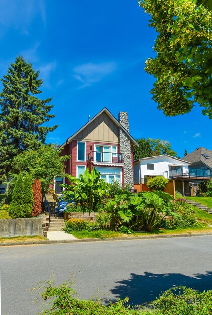 Beautiful suburban house with landscaped terraces and blue sky background