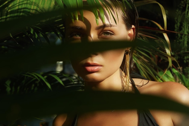 beautiful summer girl with wet Hair young sexy woman in bikini under palm tree Beauty Portrait