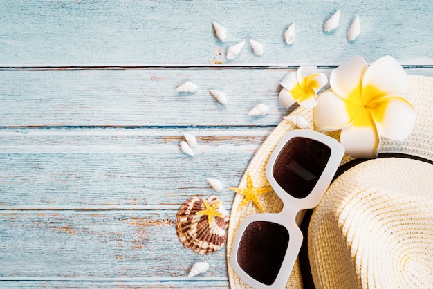 Beautiful summer holiday, Beach accessories, sunglasses, hat and shells on wooden backgrounds