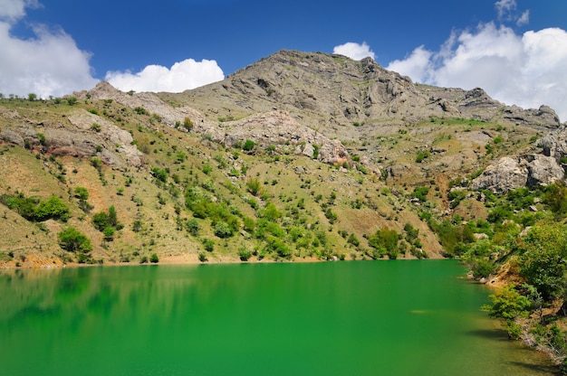 Foto bellissimo paesaggio estivo, lago con acqua azzurra situata tra le montagne rocciose