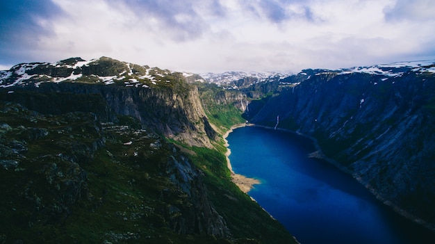 Beautiful summer vibrant view on famous Norwegian tourist place - trolltunga, the trolls tongue with a lake and mountains, Norway, Odda.