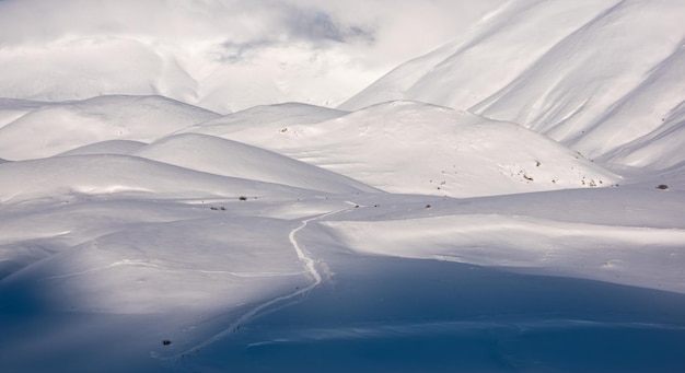 Beautiful sunlight and shades contrast on snow hills in winter