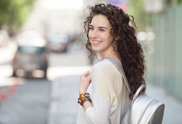 beautiful sunny portrait of a curly hair girl. Face laughing girl