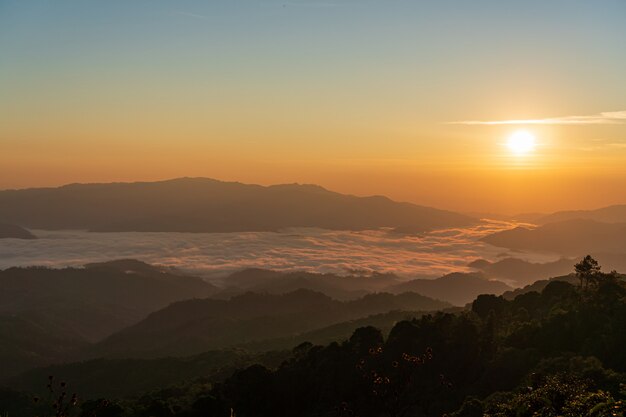 Beautiful sunrise and colorful sky in the mist over the mountain