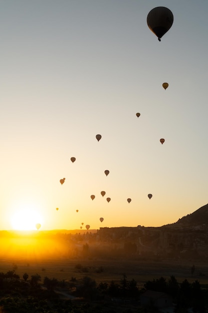 Beautiful sunrise landscape in Cappadocia with hot air balloons flying in the sky