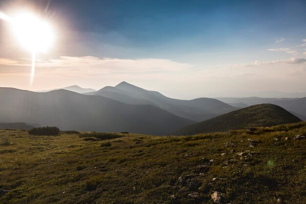 Beautiful sunrise over the mountain landscape among grassy mountain hills and meadow covered green lush grass Carpathian Mountains Ukraine