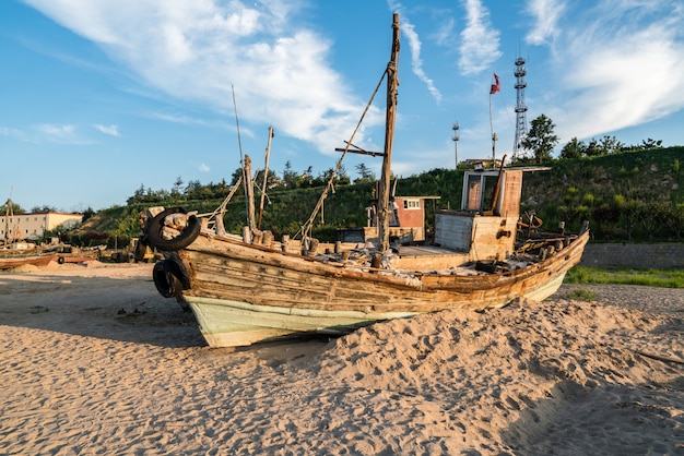 Beautiful sunrise on an old wooden fishing boat on the beach