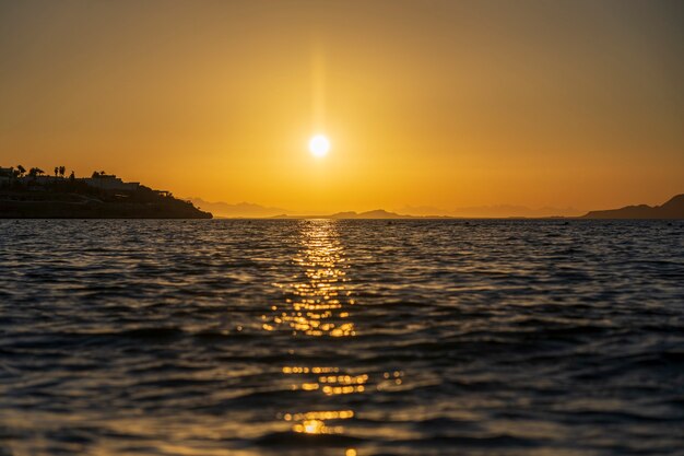 Beautiful sunrise over sea water in Sharm El Sheikh, Egypt. Travel and nature concept. Morning sky, sun and sea water