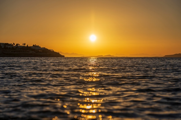 Bellissima alba sull'acqua di mare a sharm el sheikh, egitto. concetto di viaggio e natura. cielo mattutino, sole e acqua di mare