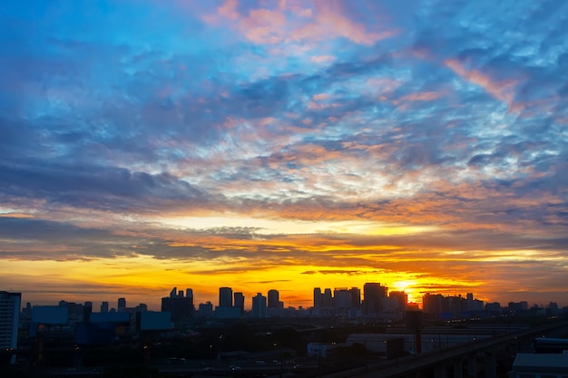 Beautiful sunrise sky with clouds in the city.