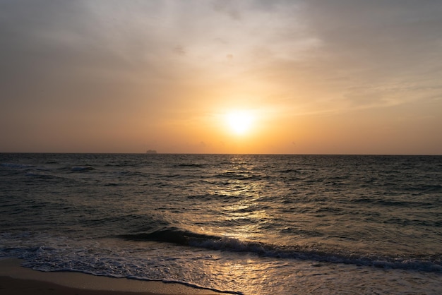 Beautiful sunrise sky with waves on sea water