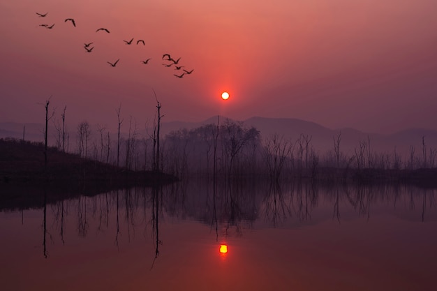 Beautiful sunrise with red sky and reflection in the lake.