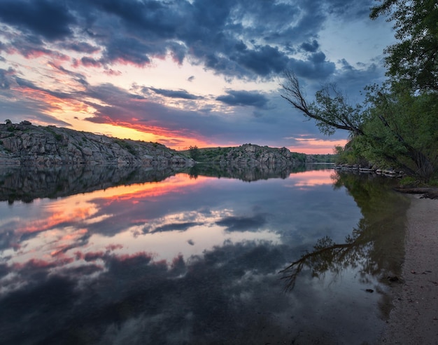 写真 ビーチでの美しい夕日 水に映る雲