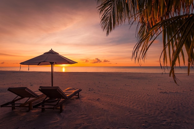 Beautiful sunset beach Chairs on the sandy beach near the sea Romantic summer holiday and vacation