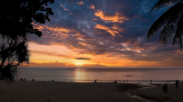 雲の空の背景とアサリの海に沈む美しい夕日熱帯のビーチに沈む夕日自然の夏のコンセプト黄色の光と海に沈む夕日は海水に反射します