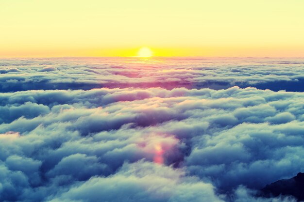 雲の上の丘の上の美しい夕日