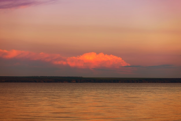 Beautiful sunset on the lake with clouds and reflections on the water