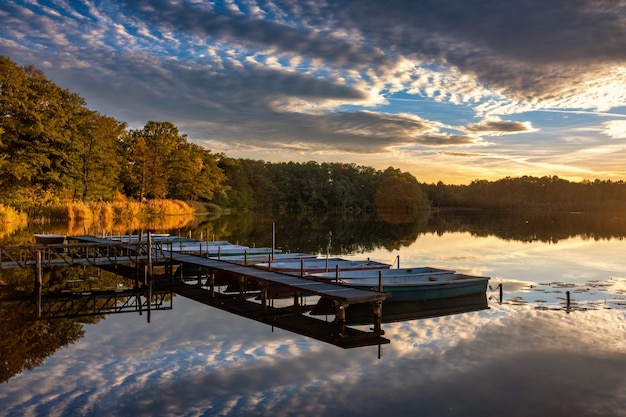 Foto bel tramonto sul lago con molo in legno