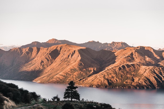 Beautiful sunset landscape of the rocky mountains surrounding the huge blue lake illuminated by