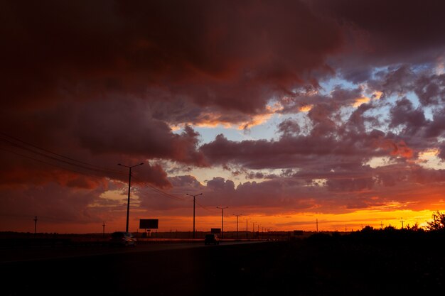 道路上の車と美しい夕日の風景。