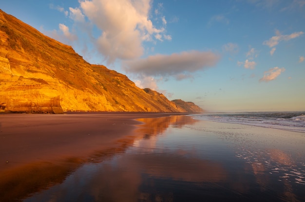 ニュージーランドのオーシャンビーチの美しい夕日。