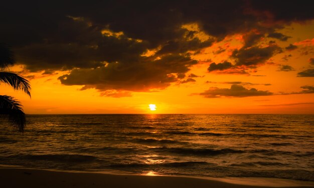 写真 熱帯のビーチで海を越えて美しい夕暮れ オレンジ色の空の背景 旅行と休暇のxa