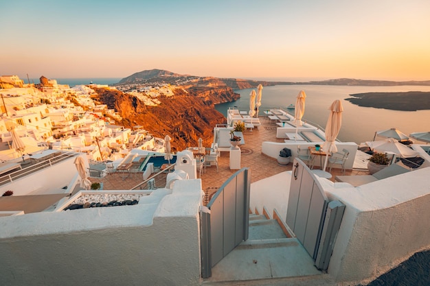 Bellissimo tramonto sull'isola di santorini in grecia sedie sulla terrazza con vista mare destinazione di viaggio