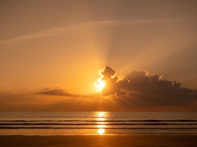 Beautiful sunset above the sea with sun ray behind the cloud background Calm sea view before dusk peaceful heaven place for escape and relaxation life Sunrise at the beach with gentle water waves