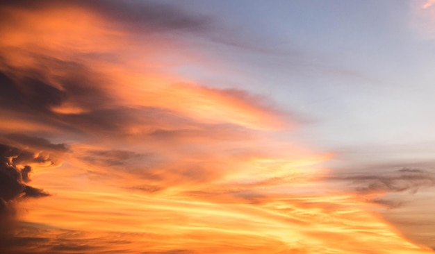 雲の上の美しい夕焼け空。オレンジ色の夕焼け空。美しい空。日没時の劇的な赤黄色のパステルカラー