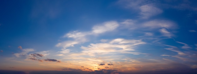 Beautiful sunset sky with clouds. Panorama of dramatic sky during golden hour.