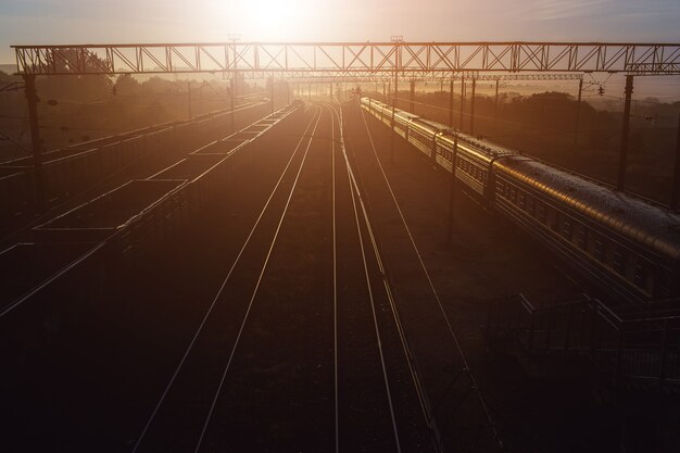 Beautiful sunset at train station with freight and passenger train.