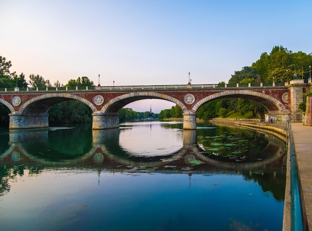 イタリア、トリノ市のポー川に架かるアーチ橋の美しい夕日の眺め