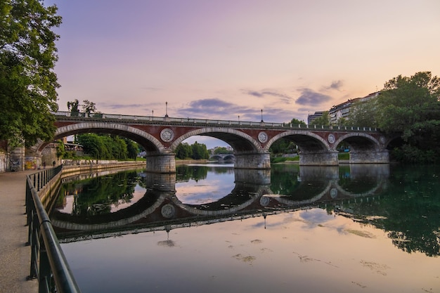 Красивый вид на закат на арочный мост через реку По в городе Турин Италия