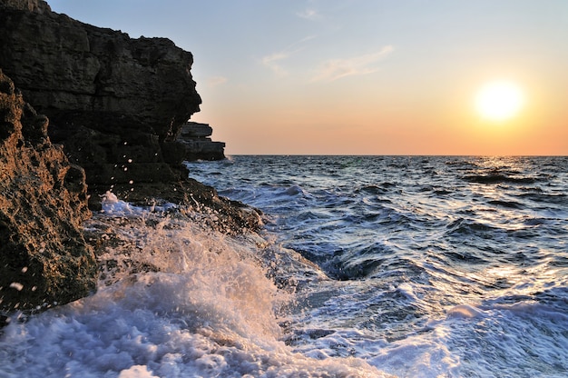 Beautiful sunset over wavy stormy Black sea rocky coastline in Crimea on summer day