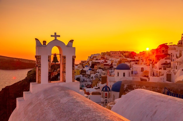 Foto bel tramonto con la famosa chiesa ortodossa sull'isola di santorini mar egeo grecia