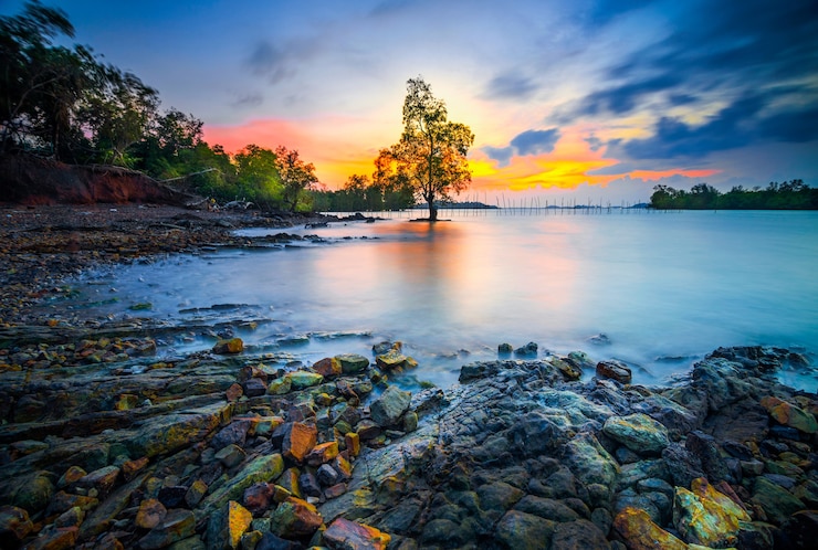 Photo beautiful sunset with rocks along the beach