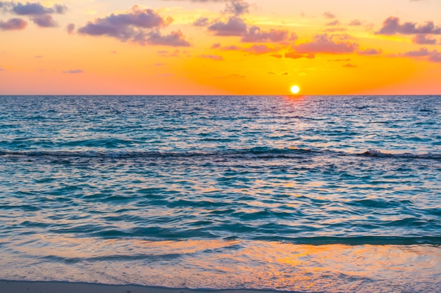 熱帯のモルディブの島の穏やかな海の上空と美しい夕日。