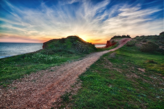 Foto un bellissimo tramonto con vista sul mare. vicino alla strada.