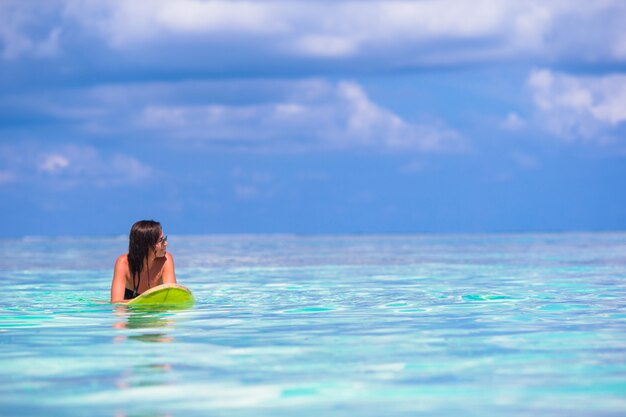 Beautiful surfer woman surfing during summer vacation