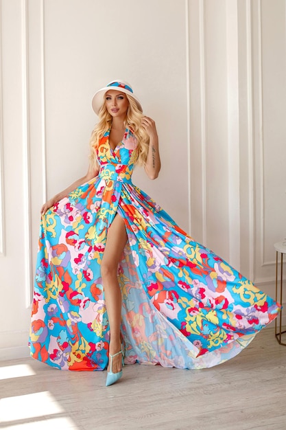 A beautiful sweet blonde woman in a bright outfit a long skirt with a flower print wavy hairstudio