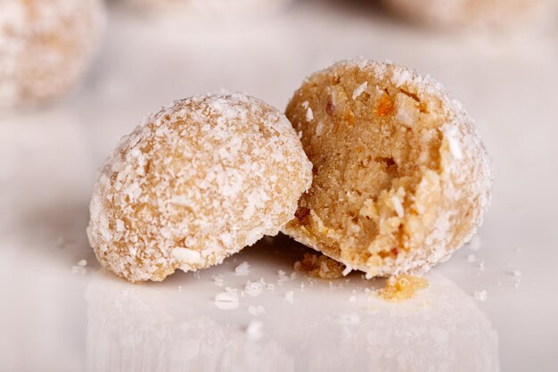 Foto bellissimi dolci con cocco su un piatto bianco su sfondo nero