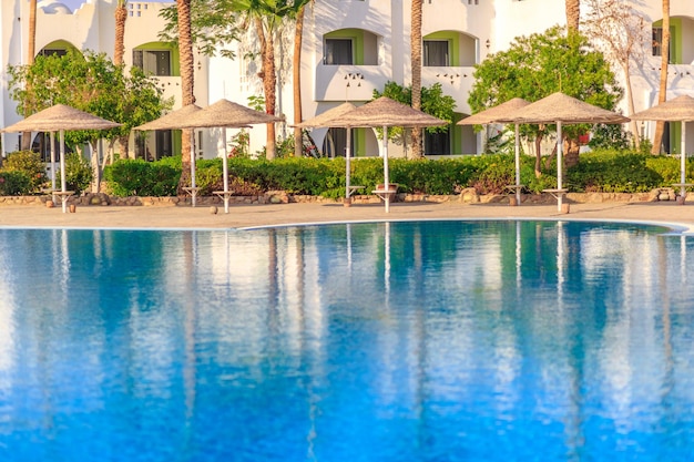 Beautiful swimming pool the luxury hotel and palm trees