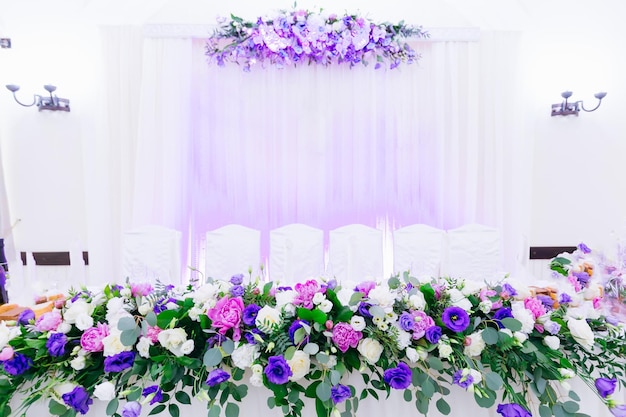 Beautiful table for newlyweds decorated with flowers wall with