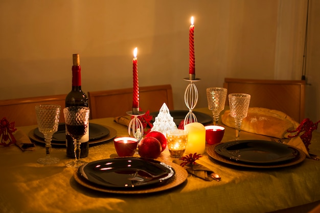 Bellissimo tavolo preparato e pronto per la cena della notte di natale con l'accogliente luce delle candele.