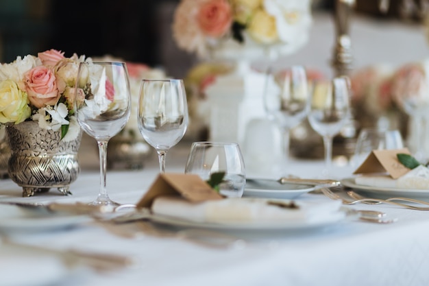 Photo beautiful table served with glassware and cultery, decorated with flowers, prepared for festive event.