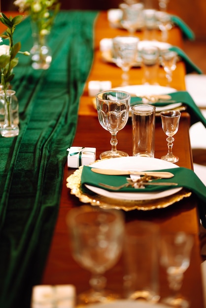 パーティーの結婚披露宴やその他のお祝いイベントのエメラルドカラーの美しいテーブルセッティング