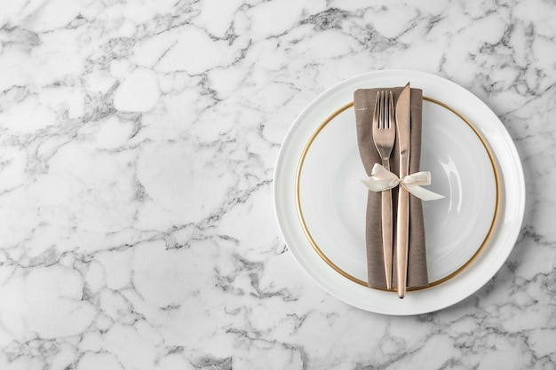Beautiful table setting on white marble background flat lay Space for text