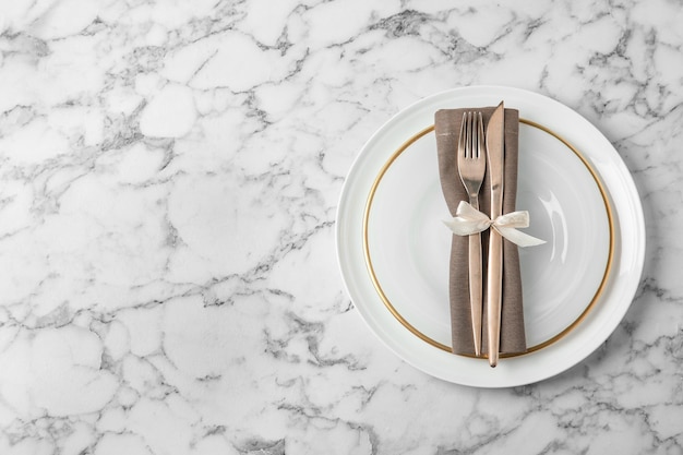 Beautiful table setting on white marble background flat lay space for text