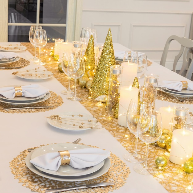 Beautiful table setting with Christmas decorations. Gold colors