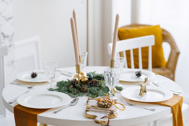 Фото Красивая сервировка стола с рождественскими украшениями в гостиной